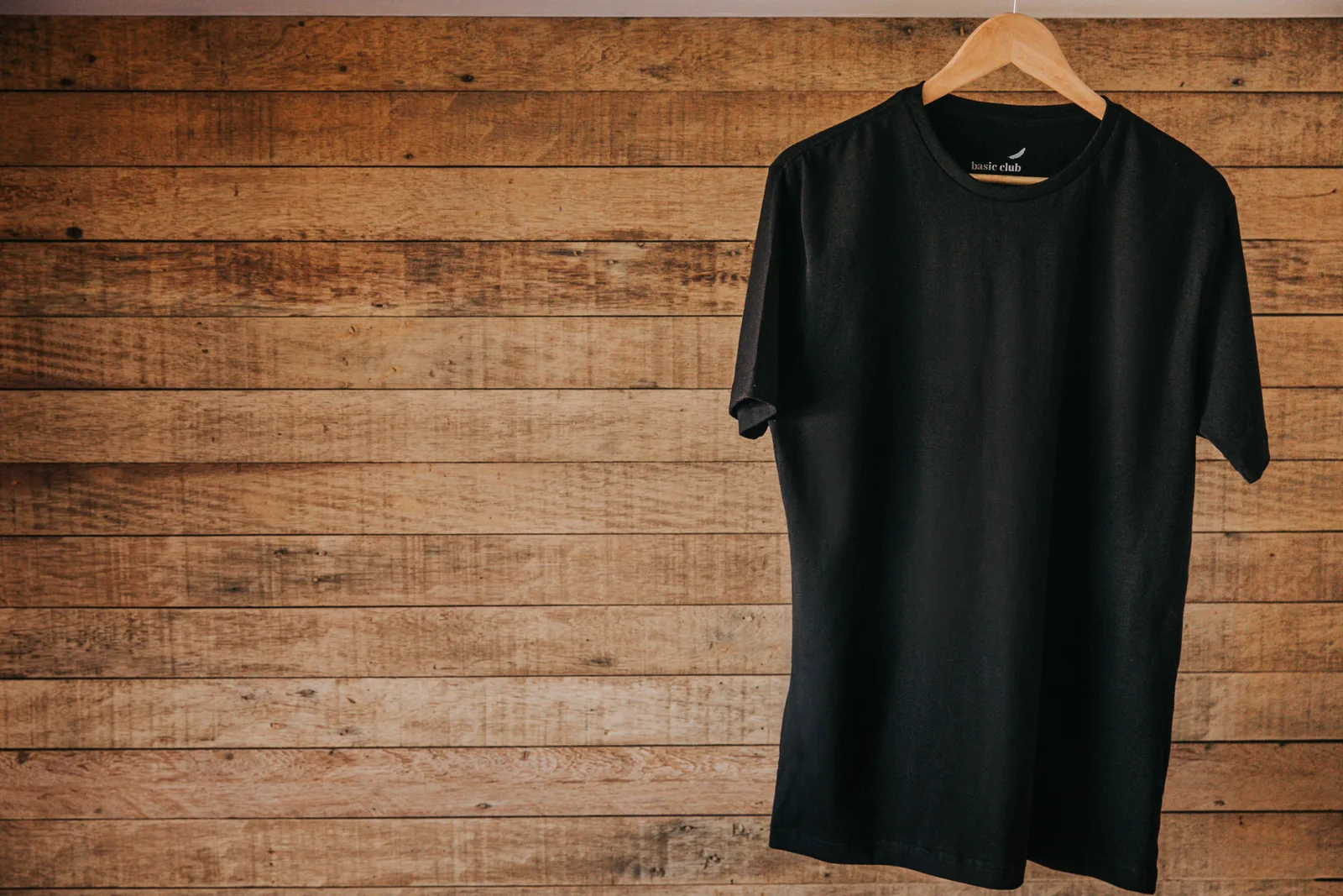 Camiseta preta Basic Club em cabide de madeira